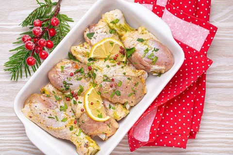 Preparing festive Christmas Eve meal with marinated chicken drumsticks. Raw chicken legs with