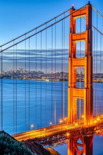 Detail of the famous Golden Gate Bridge at dawn with the San Francisco skyline in the background