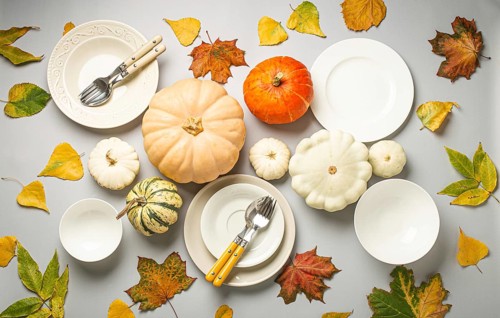 Thanksgiving festive table composition with different colourful pumpkins, autumn leaves, empty