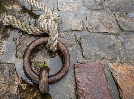 Close up image with a solid iron ring used to secure the anchoring of the ships on the docks,