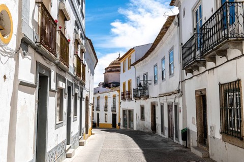 Evora, Portugal, June 30, 2022: Street in the old town with typical whitewashed houses with