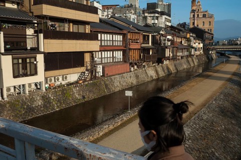 26.12.2017, Kyoto, Japan, Asia, A woman crosses a bridge over the Kamo River in Kyoto early in the