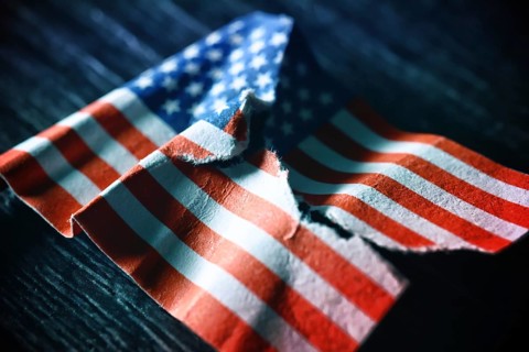 Torn US flag, symbolic photo for a divided society in the USA
