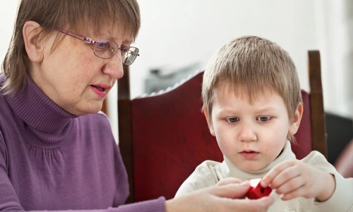 Granny is playing with her grandson at home, Belgium, Europe