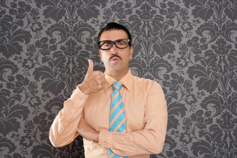 Nerd businessman gesturing ok positive with hand over retro wallpaper