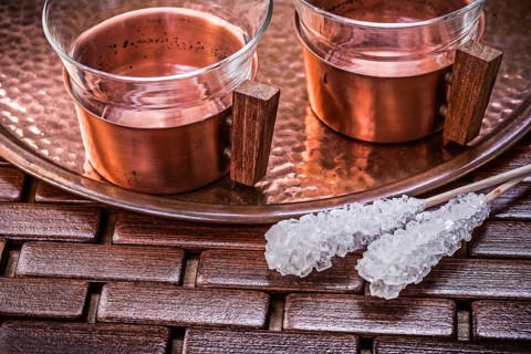 Close up view of coppery tray tea cups sugar sticks