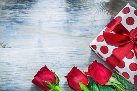 Present box red roses on wooden board holidays concept