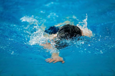 A swimmer swims in an indoor pool