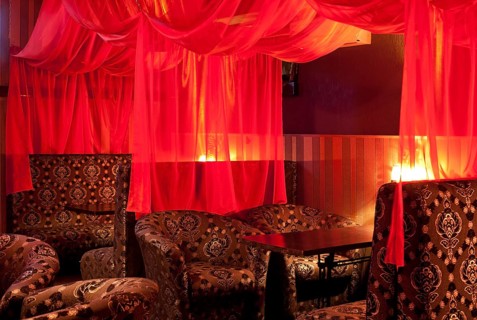 Restaurant interior (oriental style) - soft sofas and red transparent curtains