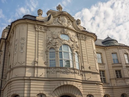 Historic building with baroque façade, elaborate reliefs and sculptures under a slightly cloudy