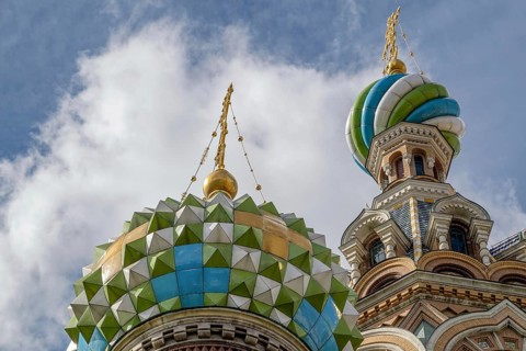 Top view of a church with colourfully decorated domes and golden spires under a cloudy sky, Saint