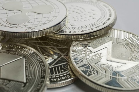 Macro photo of Ripple cryptocurrency physical coin surrounded with variety of other crypto altcoins