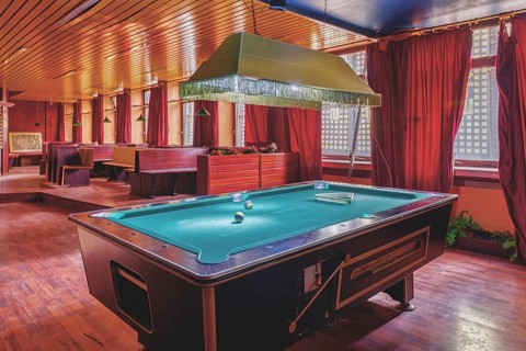 A room with a pool table in the centre, red curtains and a wooden ceiling, Bad am Park, Lost Place,