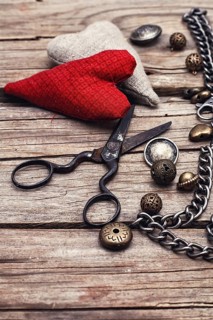 Metal chain and beads for craft on wooden background