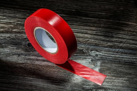 Red rolled duct tape on vintage wooden board