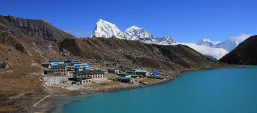Lodges in Gokyo, turquoise lake and snow covered mountain Cholatse, Nepal, Asia