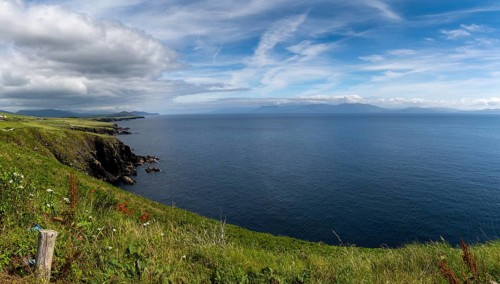Picturesque coastal landscape with green meadows and rugged cliffs on a beautiful summer day on the
