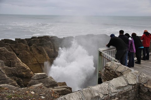 PUNAKAIKI, NEW ZEALAND, MAY 5, 2010: Tourists enjoy the main blowhole in action at the Pancake