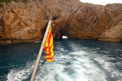 Rocks and flag at the coast Costa Brava Spain