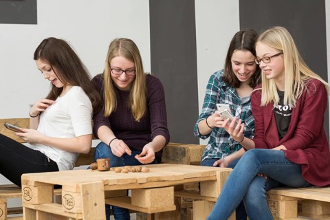 Funny group of teenagers with their smartphones