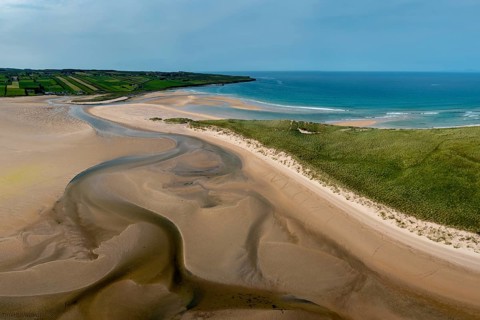 A panorama drone landscape view of the beautiful golden sand beach at Lacken Strand on the coast of