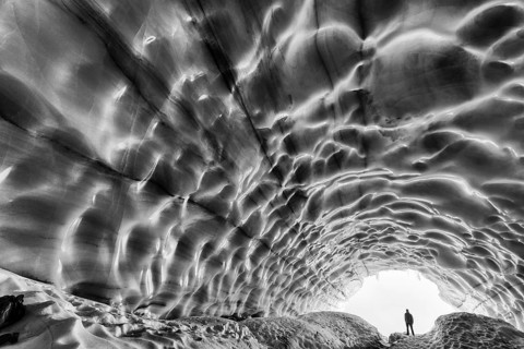 Man in an ice grotto, glacier in the Tarfaladalen valley (Darfalavaggi), Kebnekaisefjaell