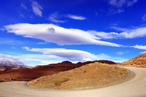 The magnificent national park Torres del Paine. The dirt road between the hills under the fabulous