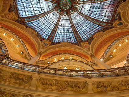 Magnificently decorated dome with colourful stained glass windows that shine in golden light, rich