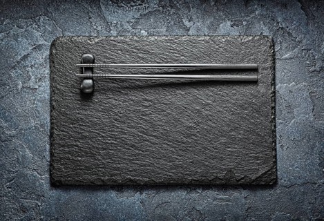 Black Choppingsticks On Rest And Stone Slate Platter