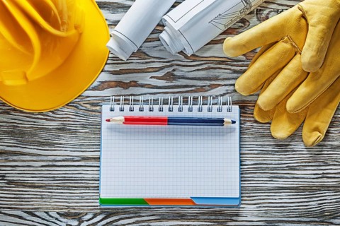 Safety gloves building helmet blueprints notepad pencil
