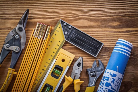 Composition of building tools on vintage wooden board top view