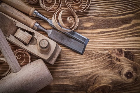 Flat chisels shaving plane curled shavings lump hammer on wooden board construction concept