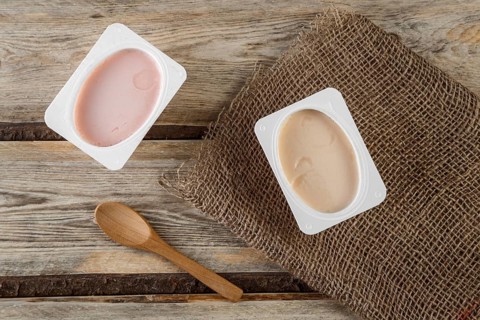 Natural organic yogurt with natural juice on a wooden background with a natural bamboo spoon