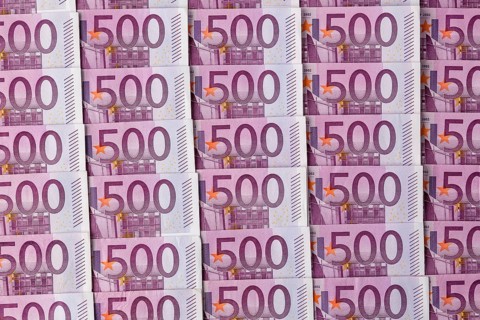 Many five hundred euro banknotes lying next to each other. Symbolic photo for wealth and investment