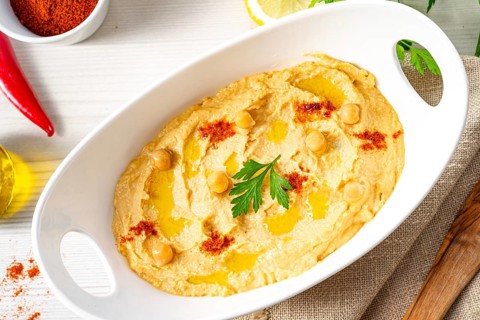 Hummus paste with lemon and chilli on a white background