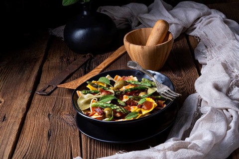 Pasta salad with green asparagus, olives and Parma ham