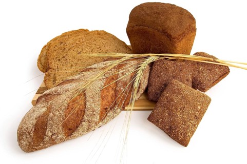 Various rye bread with a wooden board with stems of rye isolated on a white background, Russia,