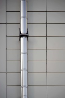 A mounted stainless steel pipe on a symmetrically arranged sheet metal façade