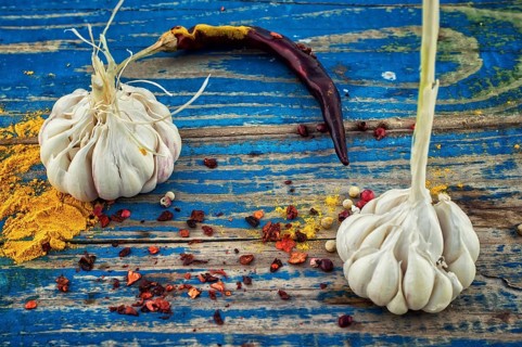 Garlic, pepper and seasoning on wooden vintage background.selective focus