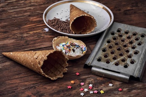 Ice cream decorated with sweet powder in the wafer on wooden background