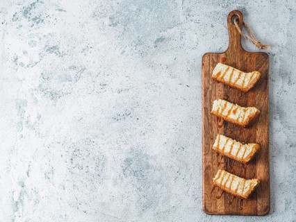 Caramelized cheesecake slices on wooden cuttingboard. Cheesecake on gray cement background with