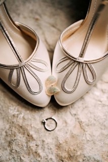 Women's earrings in the shape of leaves on the toes of the bride's white shoes with an engagement