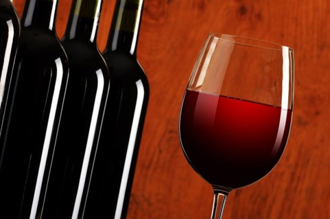 Composition with wineglass and bottles of red wine