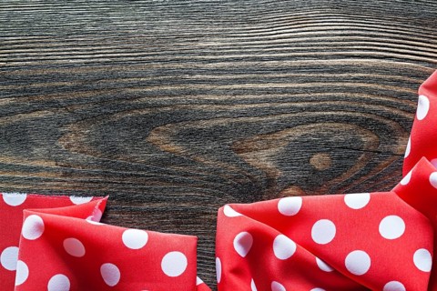 Red polka-dot table cloth on wood board top view
