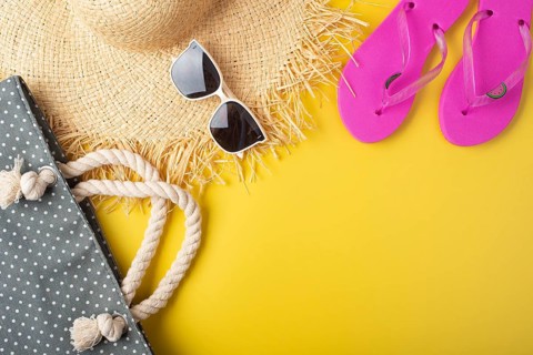 Flip flops straw hat sunglesses and beach bag on yellow background vacation travel planning mockup