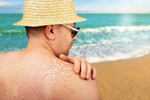 Middle aged caucasian male model applying sunscreen