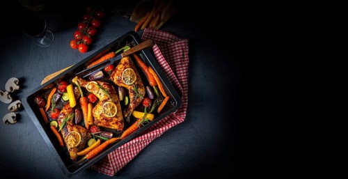 Grilled chicken legs with various vegetables and herbs