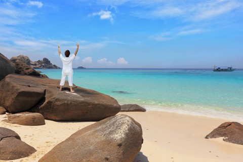 Middle-aged woman dressed in white doing yoga. Asana Blessing of the Sun. Thailand. Gorgeous beach