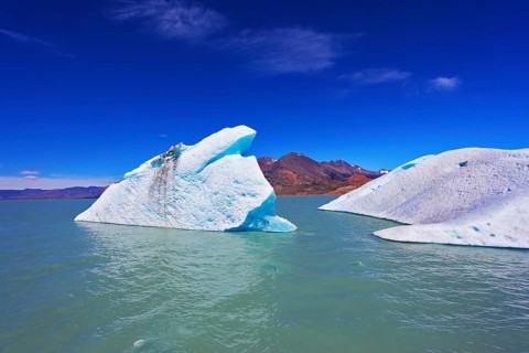 Huge white and blue icebergs floating in the icy water of emerald lake in Argentina. Unique lake