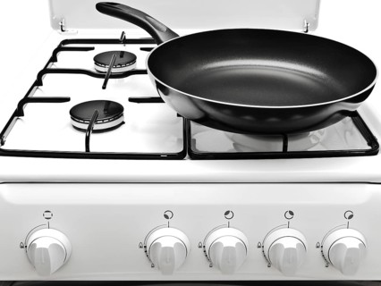 Frying Pan At The White Gas Stove Over The White Background
